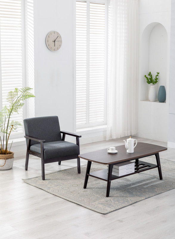 A modern living room features the Bahamas - Coffee Table And Chair (Set of 2), a white teapot and cups, a potted plant, wall clock, light rug, and large windows with sheer curtains letting in natural light.