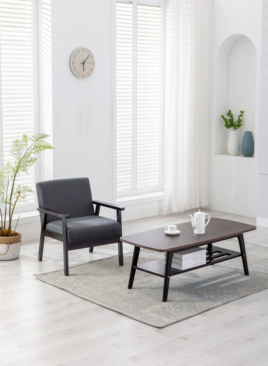 A modern living room features the Bahamas - Coffee Table And Chair (Set of 2), a white teapot and cups, a potted plant, wall clock, light rug, and large windows with sheer curtains letting in natural light.