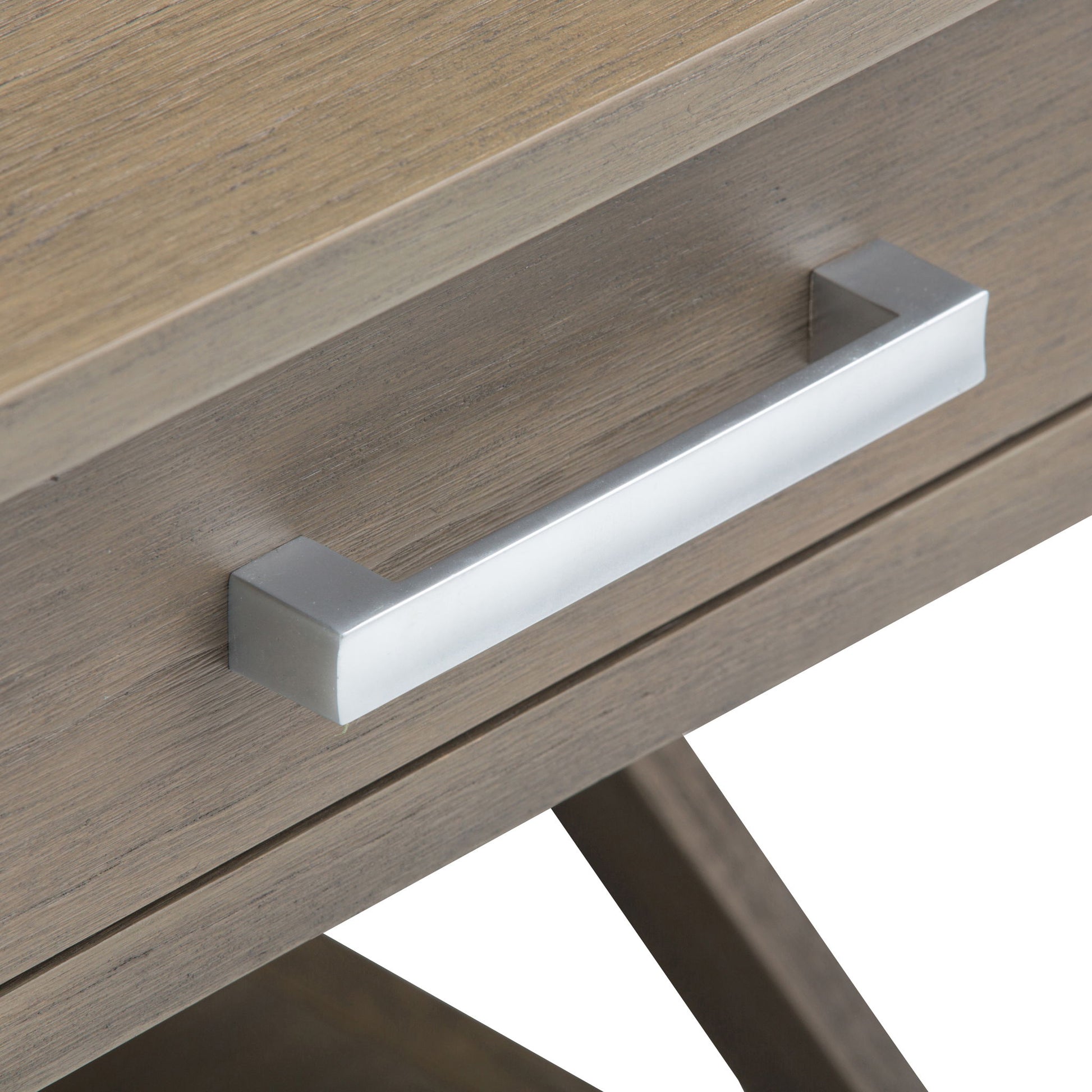 Close-up of the Kitchener - Handcrafted Table’s wooden drawer with a light brown finish and a rectangular, metallic silver handle featuring a modern, minimalist design.