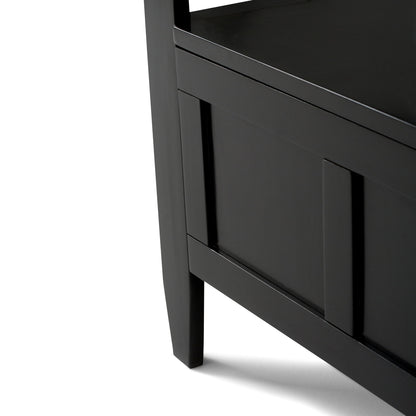 Close-up of the lower corner of the Brooklyn - Handcrafted Entryway Storage Bench, featuring black wood, clean lines, and panel detail. The bench casts a shadow on a white background.