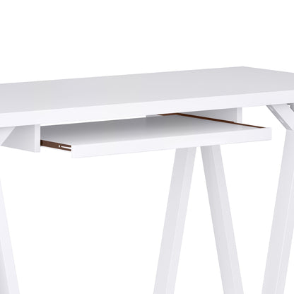 The Sawhorse - Handcrafted Desk is shown from a side angle, featuring a white finish, pull-out keyboard tray, and angled legs, set against a plain background.
