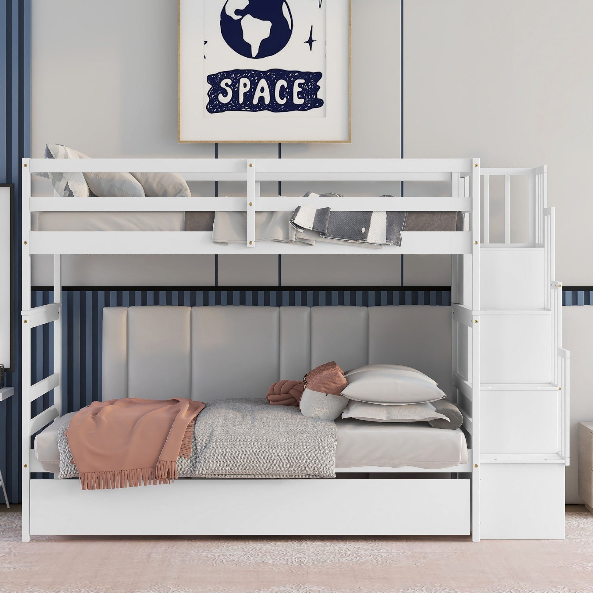 A white Twin Over Twin Bunk Bed with Trundle and Stairway Storage is neatly made with pillows and a peach blanket. The lower bunk features a padded gray headboard, and space-themed art hangs above on the wall.