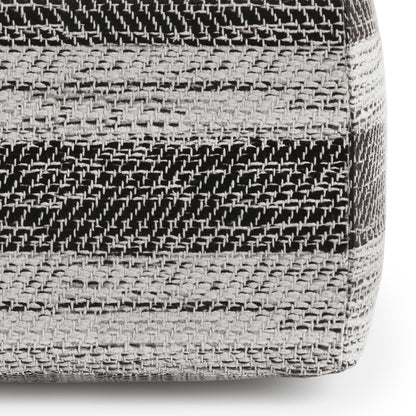 Close-up of Clay - Square Pouf, Upholstered, featuring a woven pattern with horizontal black, gray, and white stripes on its textured fabric side.