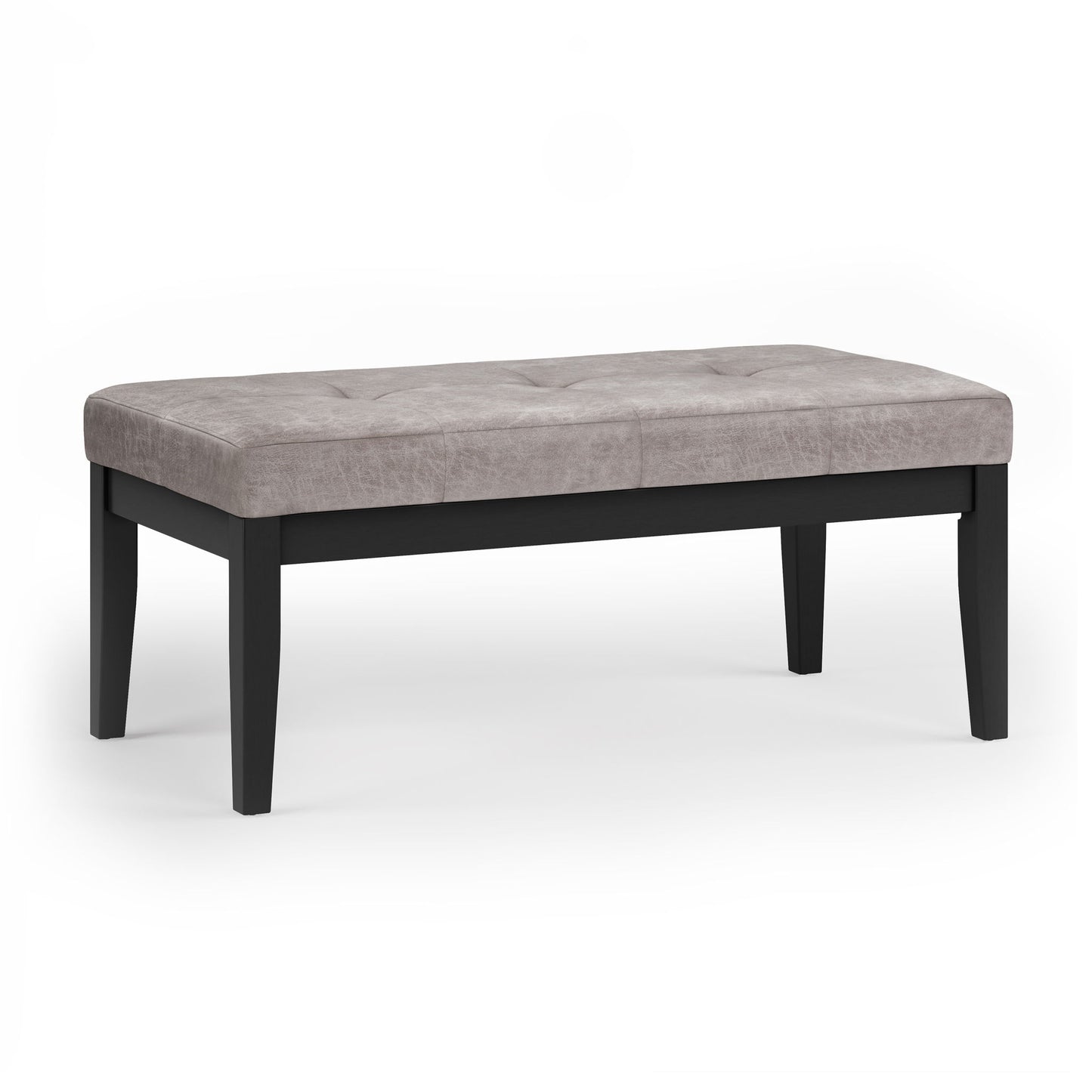 The Lacey Upholstered Tufted Ottoman Bench features a light gray cushioned, tufted seat and four black wooden legs, displayed on a white background.