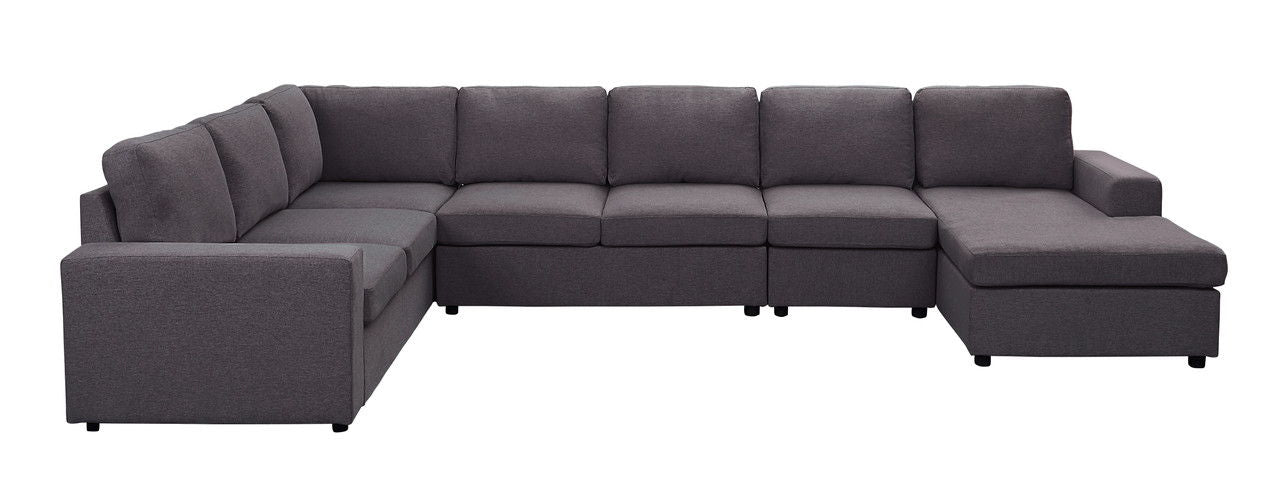 The Tifton - Linen 7 Seat Reversible Modular Sectional Sofa Chaise features dark gray upholstery and cushioned seats and backs in a spacious, modern L-shaped design, displayed against a white background.