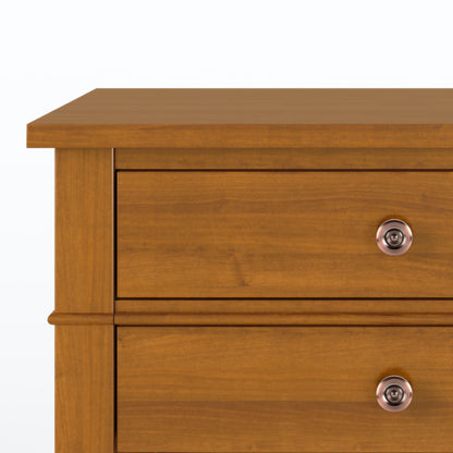 A close-up of the top two drawers of the Carlton Handcrafted Bedside Table, made of wood with a warm brown finish and featuring round metal knobs on each drawer.