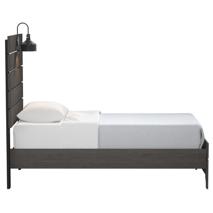 The Junipe - Bed With Lights is a modern single bed featuring a dark wood frame, white pillow and sheet, light gray blanket, and a built-in black lamp on the headboard. Shown from the side against a white background.