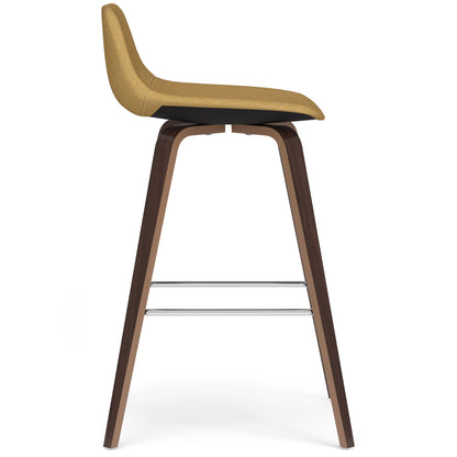 The Randolph Bentwood - Counter / Bar Height Stool (Set of 2) features a mustard yellow upholstered seat, dark wooden legs, and two horizontal metal footrests, shown in profile against a white background.