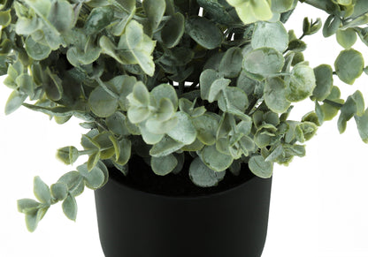 A close-up of lush eucalyptus leaves in a black pot, featuring the 11" tall Artificial Eucalyptus Grass (Set of 2), perfect for indoor decor with dense green faux foliage against a mostly white background.