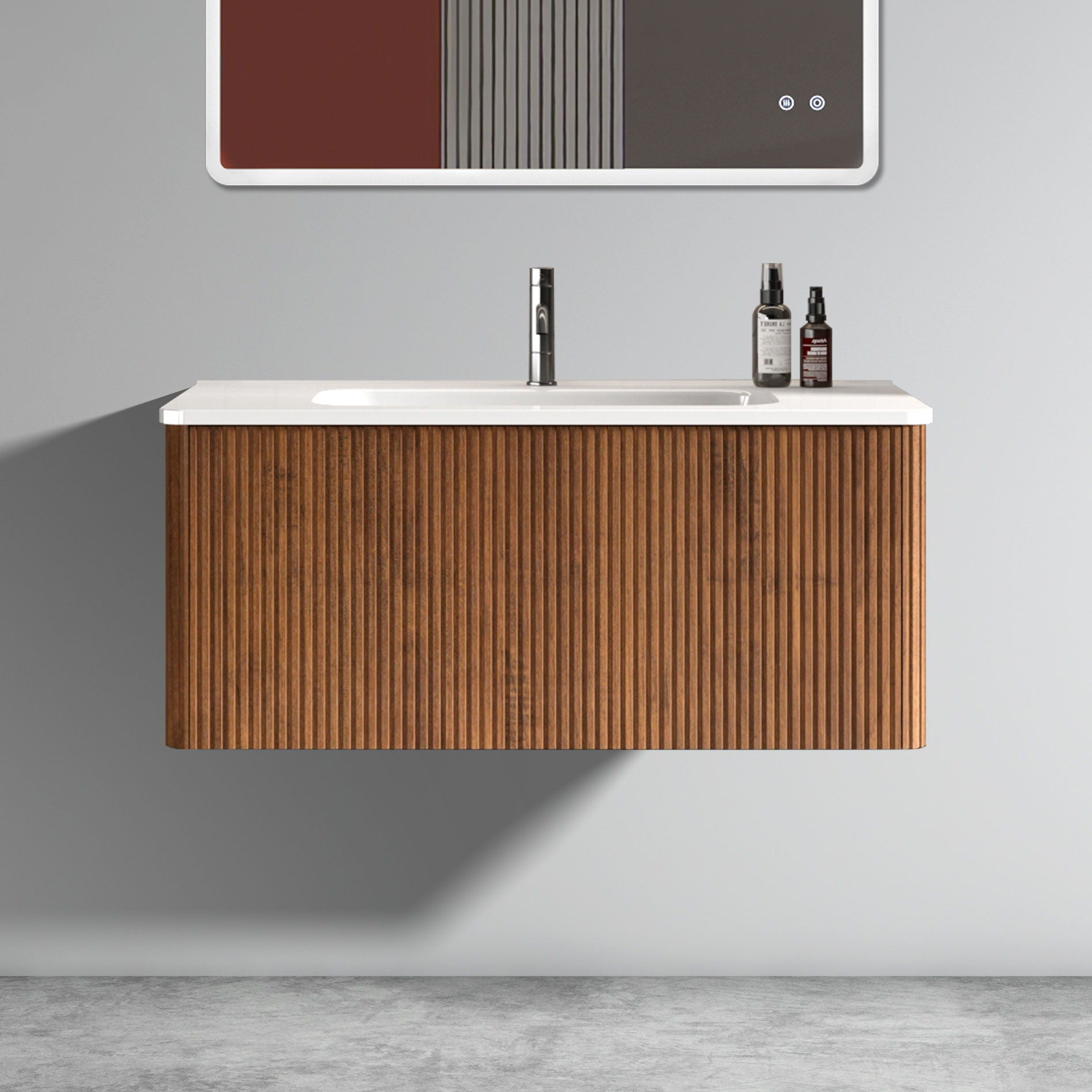 The Etna Striped Bathroom Vanity features a ribbed wooden cabinet, ceramic sink, and chrome faucet. Two bottles sit on the right of the white countertop. Minimalist decor with a gray wall and concrete floor completes the modern look.