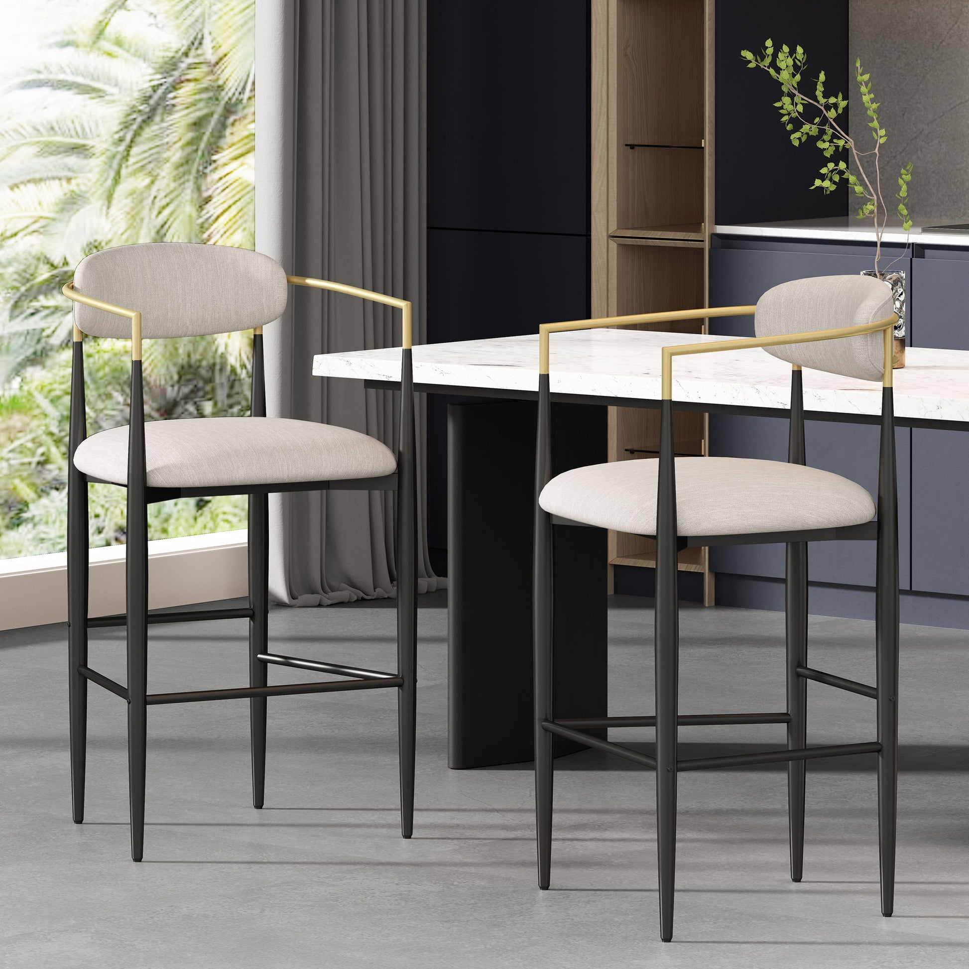Two Counter Height Upholstered Barstools (Set of 2) with beige cushions, black legs, and gold armrests are placed by a marble kitchen island, with large windows, views of palm trees, and gray curtains in the room.