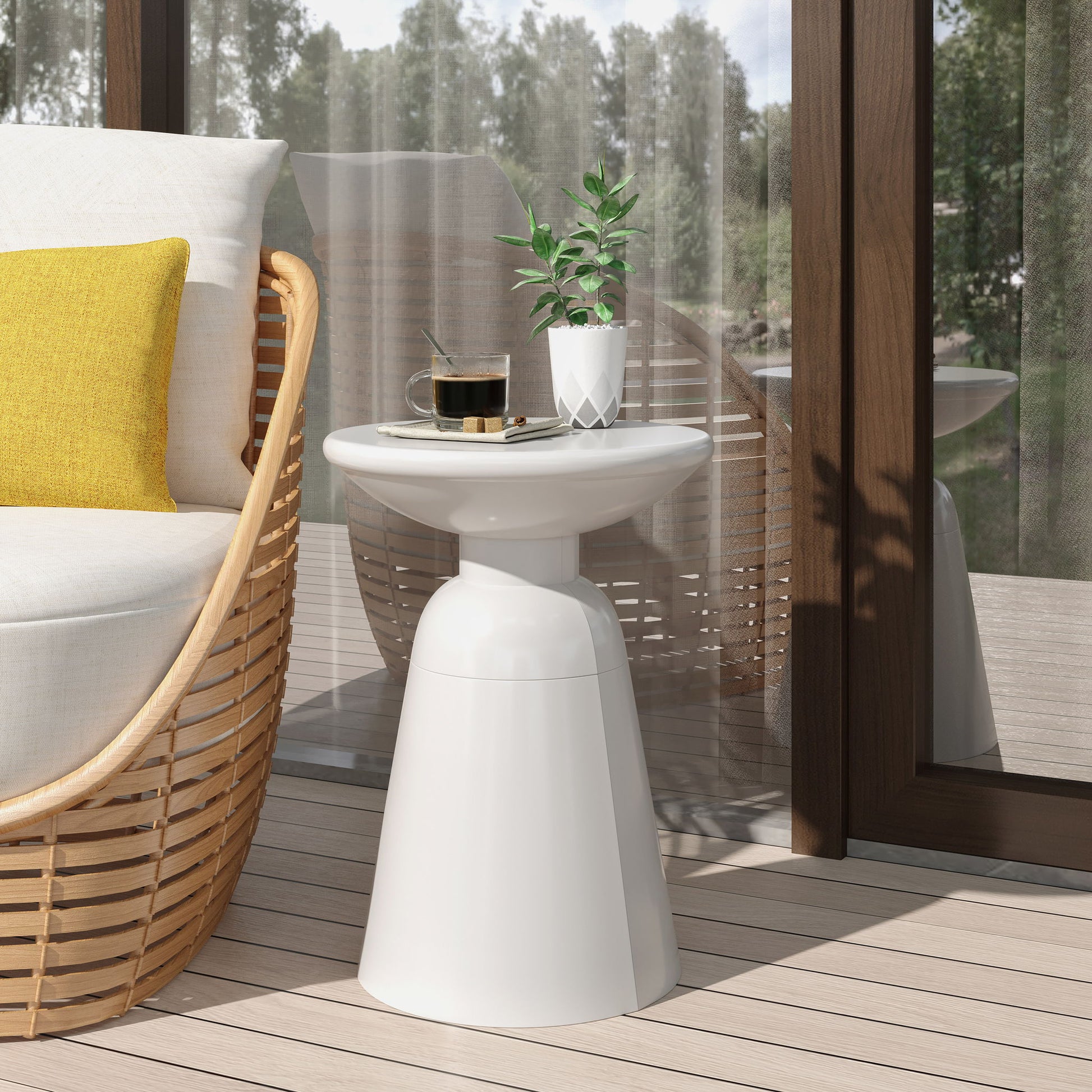 A modern patio features a wicker chair with a yellow cushion and an Outdoor Modern Metal End Large Table holding a coffee cup, saucer, spoon, and potted plant. Glass doors and trees can be seen in the background.