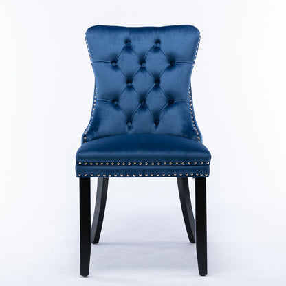 The Nikki set includes two modern, high-end dining chairs featuring blue velvet upholstery, tufted backrests, silver nailhead trim, and black solid wood legs, displayed against a plain white background.