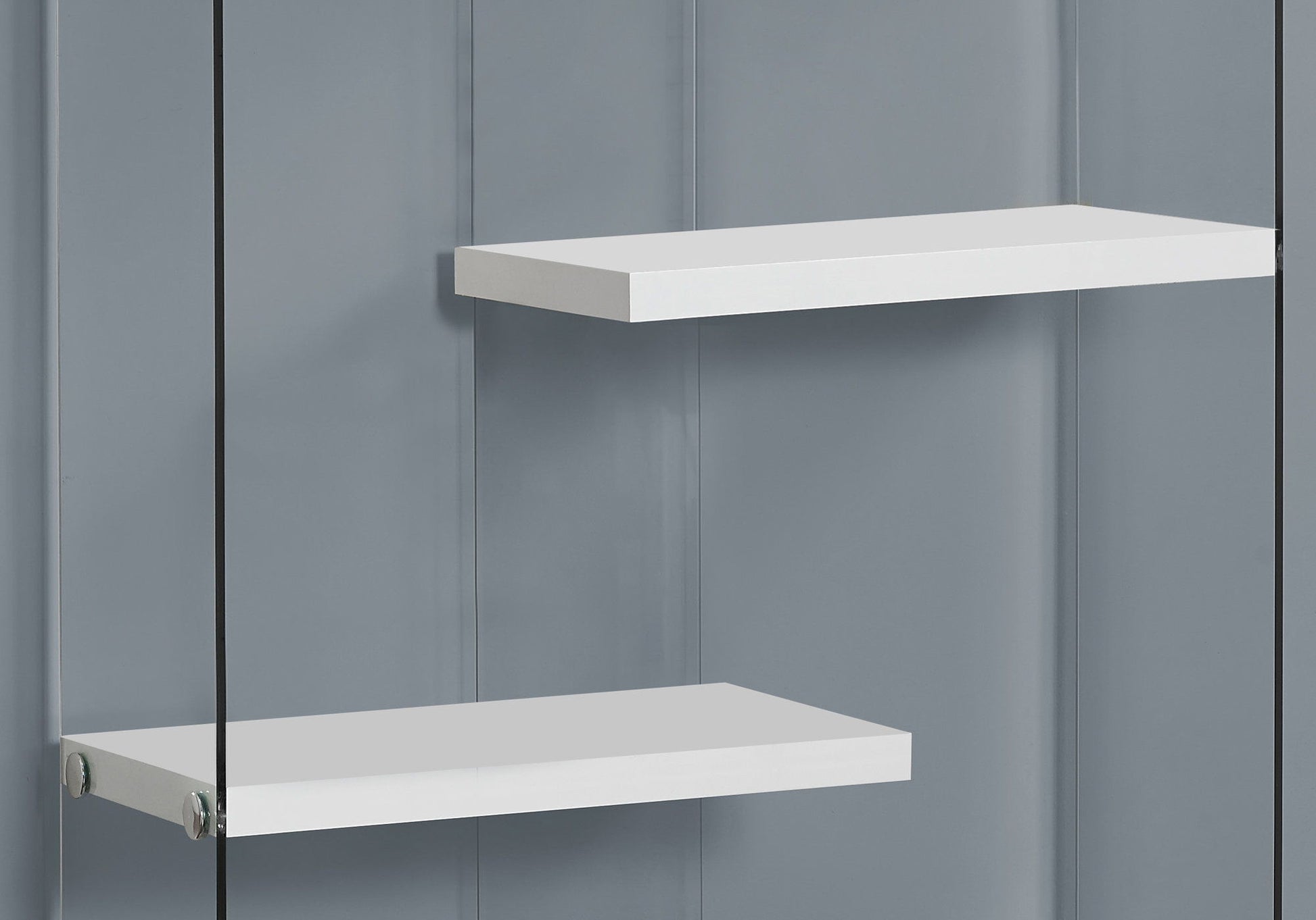 A glossy white contemporary 5-tier bookshelf stands against a smooth gray wall, showcasing a minimal and modern aesthetic with ample space between each tier.