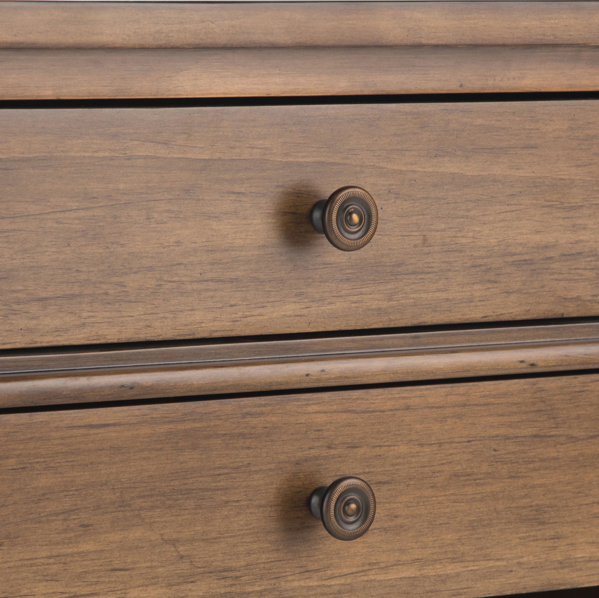 Close-up of two drawers on the Carlton Bedside Table in Rustic Natural Aged Brown, each featuring a round dark metal knob and natural wood grain patterns.