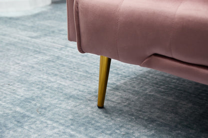 A close-up of the Comfort Compact Design Sofa Bed, featuring pink upholstery and gold metal legs, placed on a light blue textured carpet.