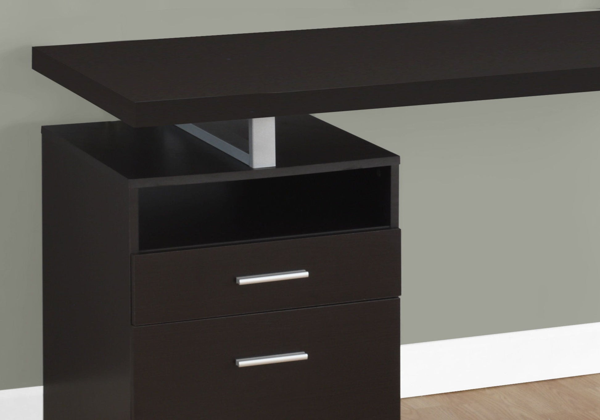 A Computer Desk For Home Office with a modern dark brown finish features two storage drawers with silver handles and an open shelf, set against a light gray wall and light wood floor. Suitable for left or right setup, perfect for laptops.