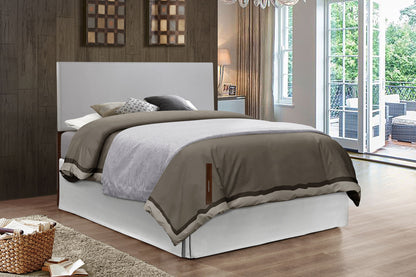 A modern bedroom features the Nova Headboard on a neatly made bed with gray and beige bedding, wood-paneled walls, large windows, a light rug, a basket of books, and patio furniture visible through glass doors.