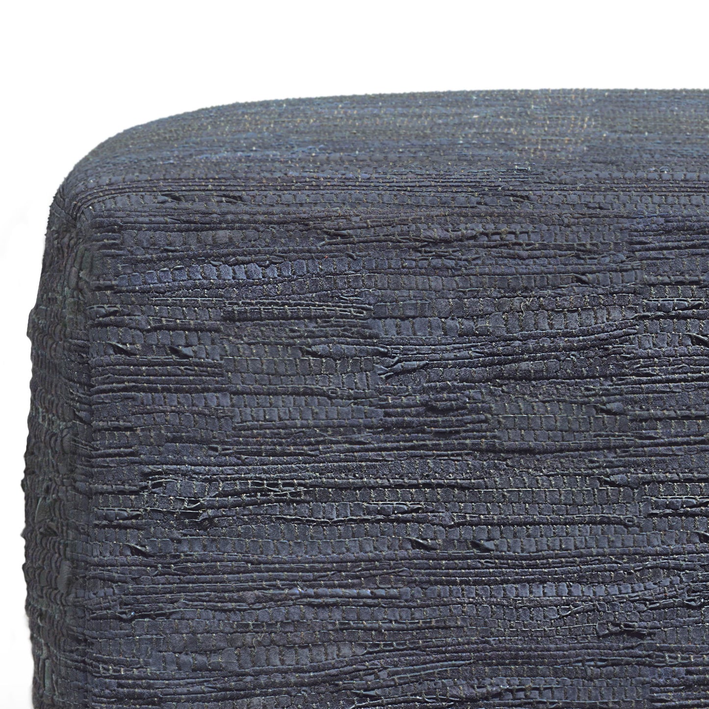 Close-up of Fredrik - Handcrafted Square Pouf in dark blue textured fabric with uneven horizontal stitches, tightly wrapped around its edge. The background is plain white.