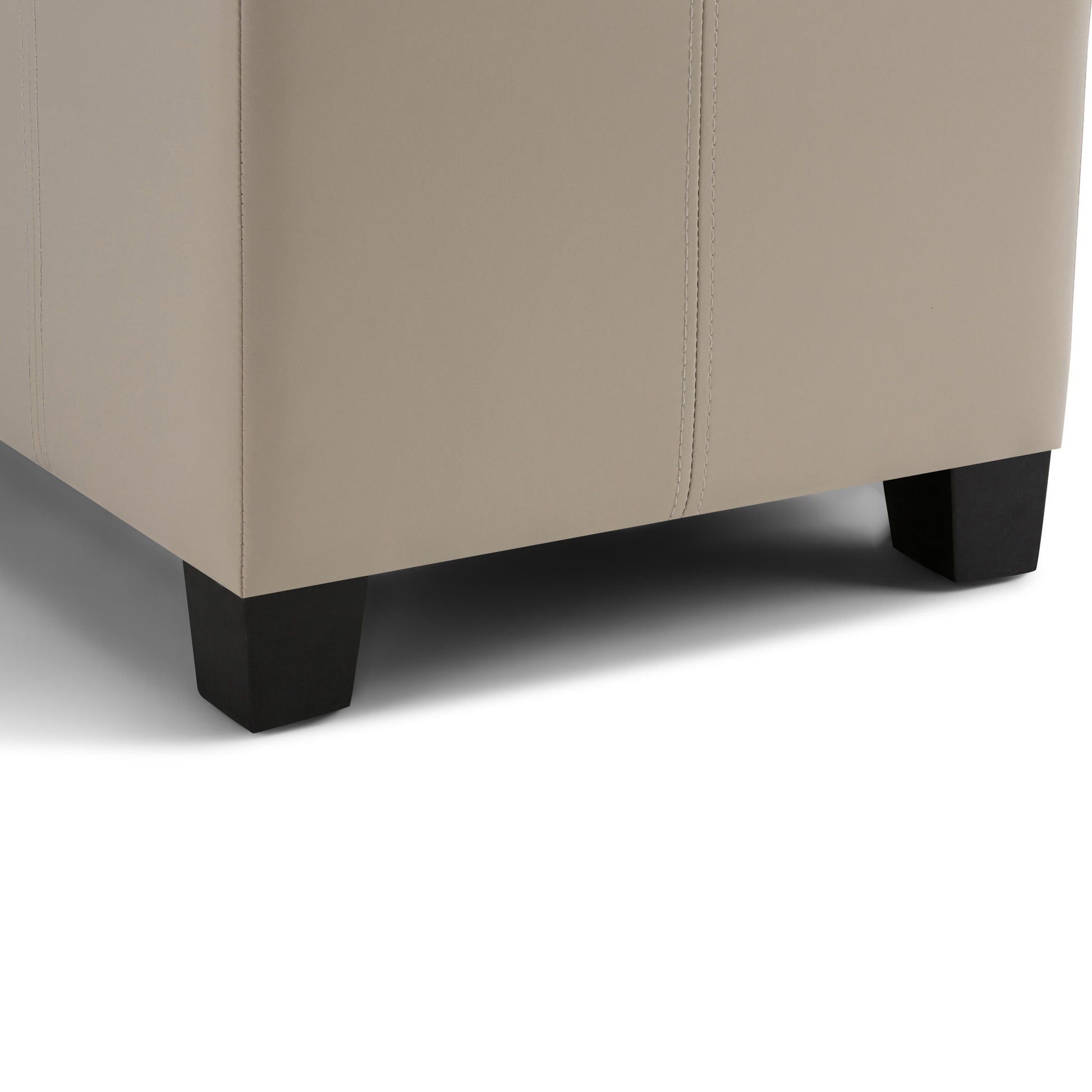 Close-up of the bottom corner of the Dover Upholstered Storage Ottoman Bench in beige, featuring dark wooden legs and visible fabric stitching.