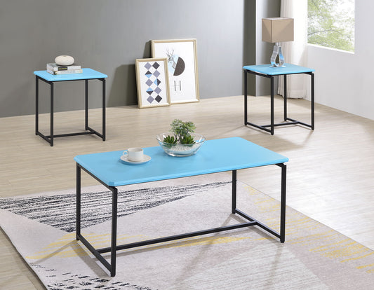 The GT - 3 Piece Carbon Fiber Wrap Coffee Table And End Table set features modern blue tops and black metal legs, arranged in a bright room with light wood floors, accented by a lamp, books, decor, framed art, and natural light from a large window.