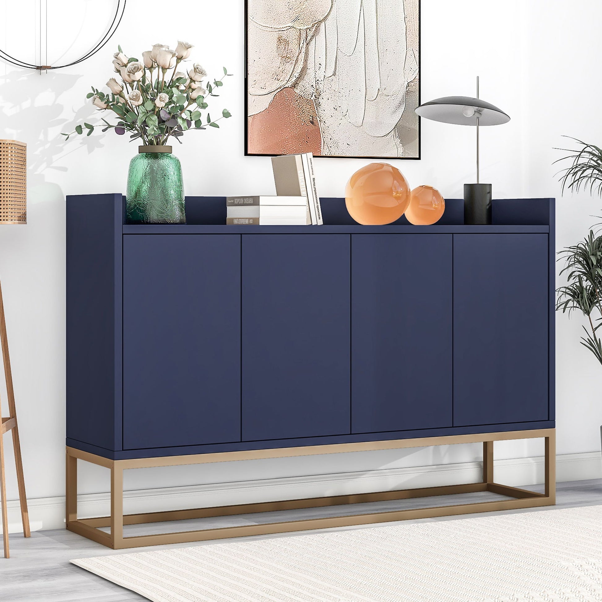 A Modern Sideboard Elegant Buffet Cabinet With Large Storage Space For Dining Room, Entryway, featuring gold legs, stands against a white wall. Decor includes vases with flowers, orange glass spheres, books, a sleek lamp, and abstract artwork above.