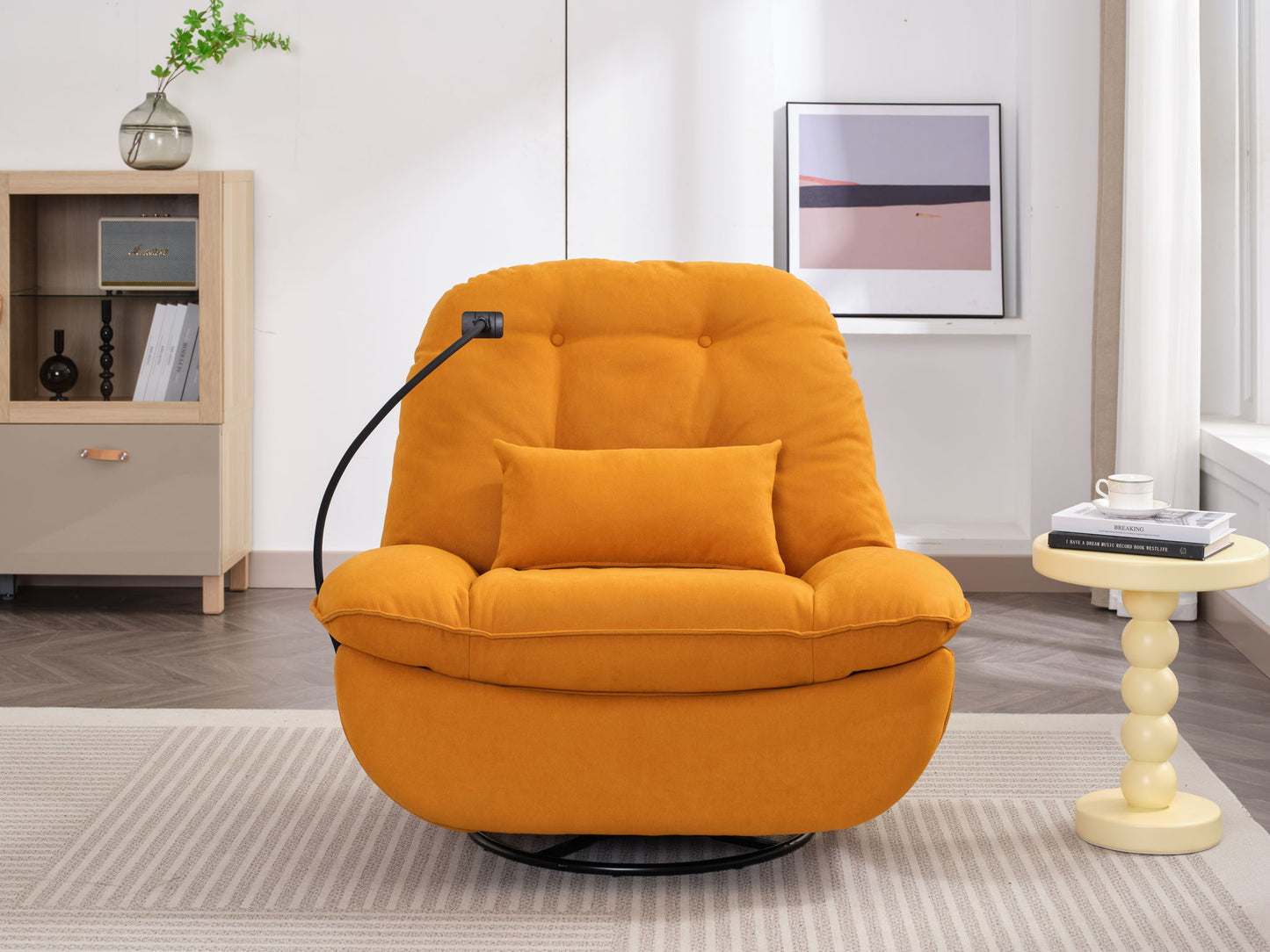 A Power Recliner Swivel Glider with USB charger and Bluetooth music player sits in a bright living room, paired with a small round yellow side table holding books and a cup, a wooden shelf, and framed artwork on the wall.