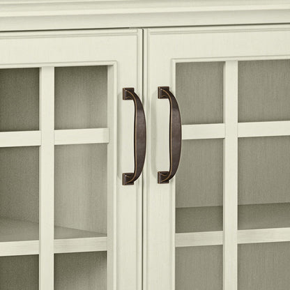 Close-up of two bronze handles on the white-framed glass doors of the Connaught - Handcrafted Low Storage Cabinet, with interior shelves visible through the glass panels.