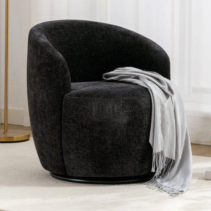 The Chenille Fabric Swivel Accent Armchair Barrel Chair with a black, rounded back sits on a light carpet, draped with a soft, light gray fringed throw. In back are white curtains and a gold floor lamp.