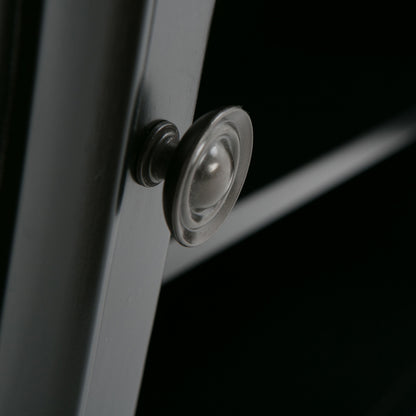Close-up of the Amherst - TV Media Stand, Handcrafted, showcasing a round metallic knob on a dark cabinet door with shelves in the background.