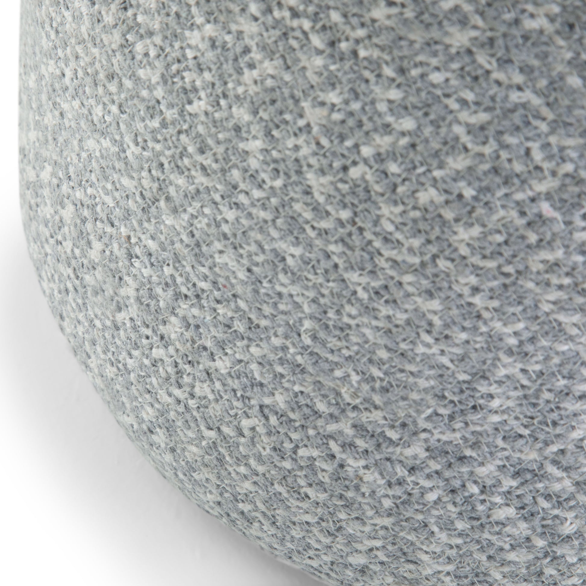 Close-up of the Bayley - Versatile Round Braided Pouf, featuring a textured, light gray woven fabric on its rounded surface.