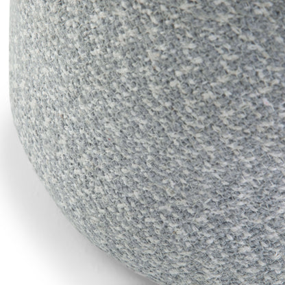 Close-up of the Bayley - Versatile Round Braided Pouf, featuring a textured, light gray woven fabric on its rounded surface.