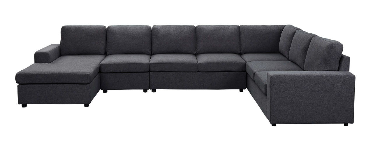 The Hayden - Linen 7 Seat Reversible Modular Sectional Sofa Chaise is a large, dark gray L-shaped sofa with plush seat and back cushions, a chaise on the left, an armrest on the right, shown against a white background.