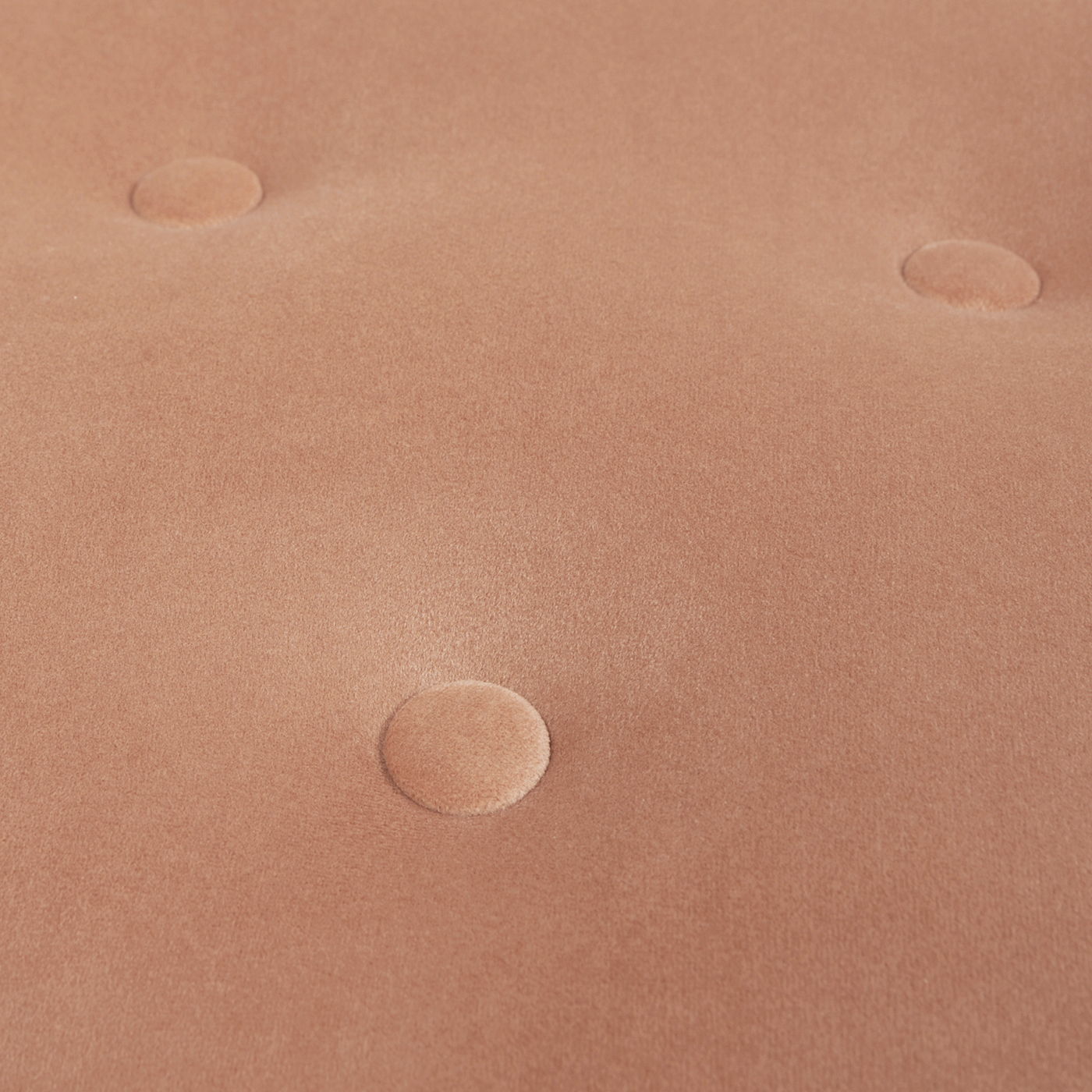 Close-up of the Yolanda Round Upholstered Accent Ottoman's soft, light brown tufted fabric surface with four evenly spaced, indented buttons.
