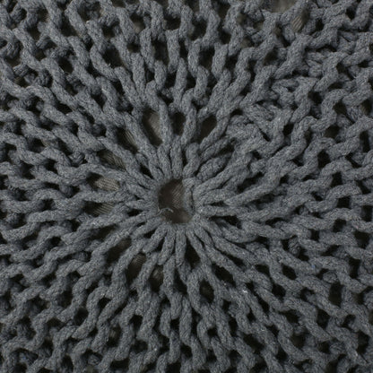 Close-up of the Bordeaux Knitted Cotton Round Pouf shows its gray, open-knit sunburst design with a center hole, allowing the background fabric to show through. This versatile ottoman also works as a stylish floor cushion.