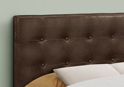 Close-up of the Full Size Upholstered Transitional Bed Headboard in brown, featuring tufted detailing and button accents behind bed pillows. A soft, muted green wall serves as the backdrop.