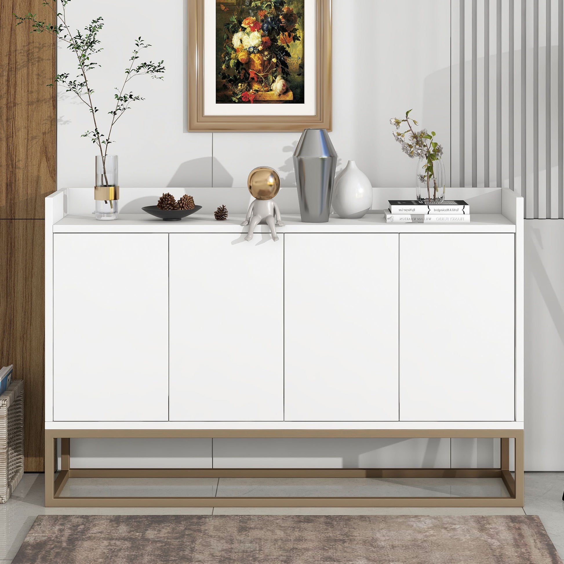 The Modern Sideboard Elegant Buffet Cabinet With Large Storage Space for dining rooms or entryways features gold legs and is styled with vases, books, pine cones, and a small figurine beneath a floral painting on a paneled wall.