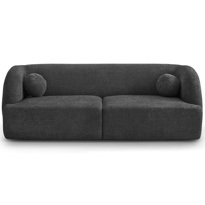 The Anna - French Boucle Sofa is a modern, dark gray piece with textured fabric, rounded edges, and two matching round cushions, photographed against a white background.