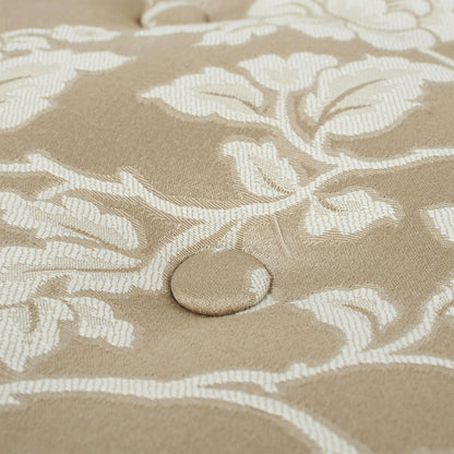 Close-up of the Yolanda Round Upholstered Accent Ottoman featuring a beige fabric with a white floral pattern and a centered, fabric-covered button tuft showcasing its detailed texture and design.