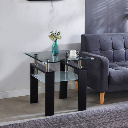 The Clear Glass Top Side Table, Modern Design For Home, features black legs and holds a green vase with flowers, a coffee cup on a saucer, and a book beside a gray sofa on tiled flooring in a bright, contemporary room.