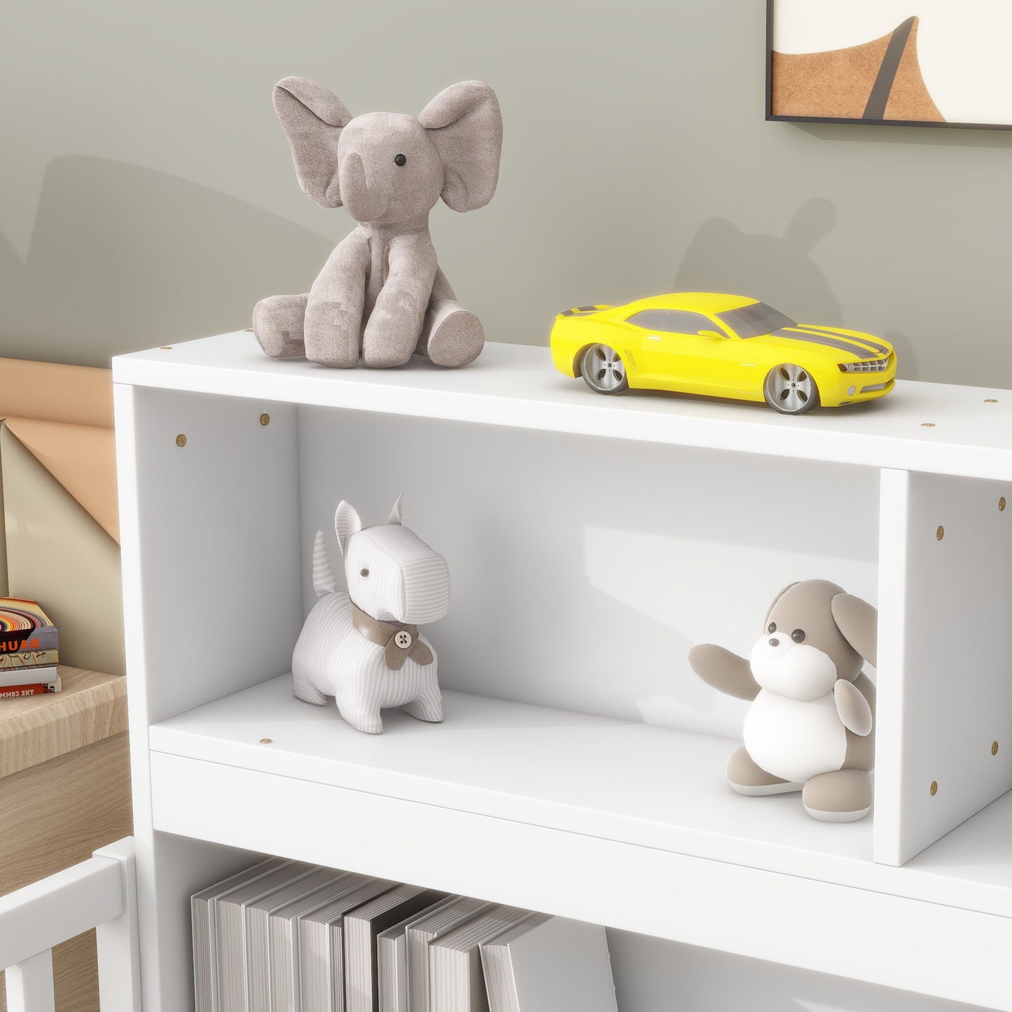 A Floor Bed With Bedside Bookcase featuring a white shelf with a gray plush elephant and yellow toy car on top, a striped plush dog and brown-and-white plush toy on the middle shelf, and books neatly arranged below.