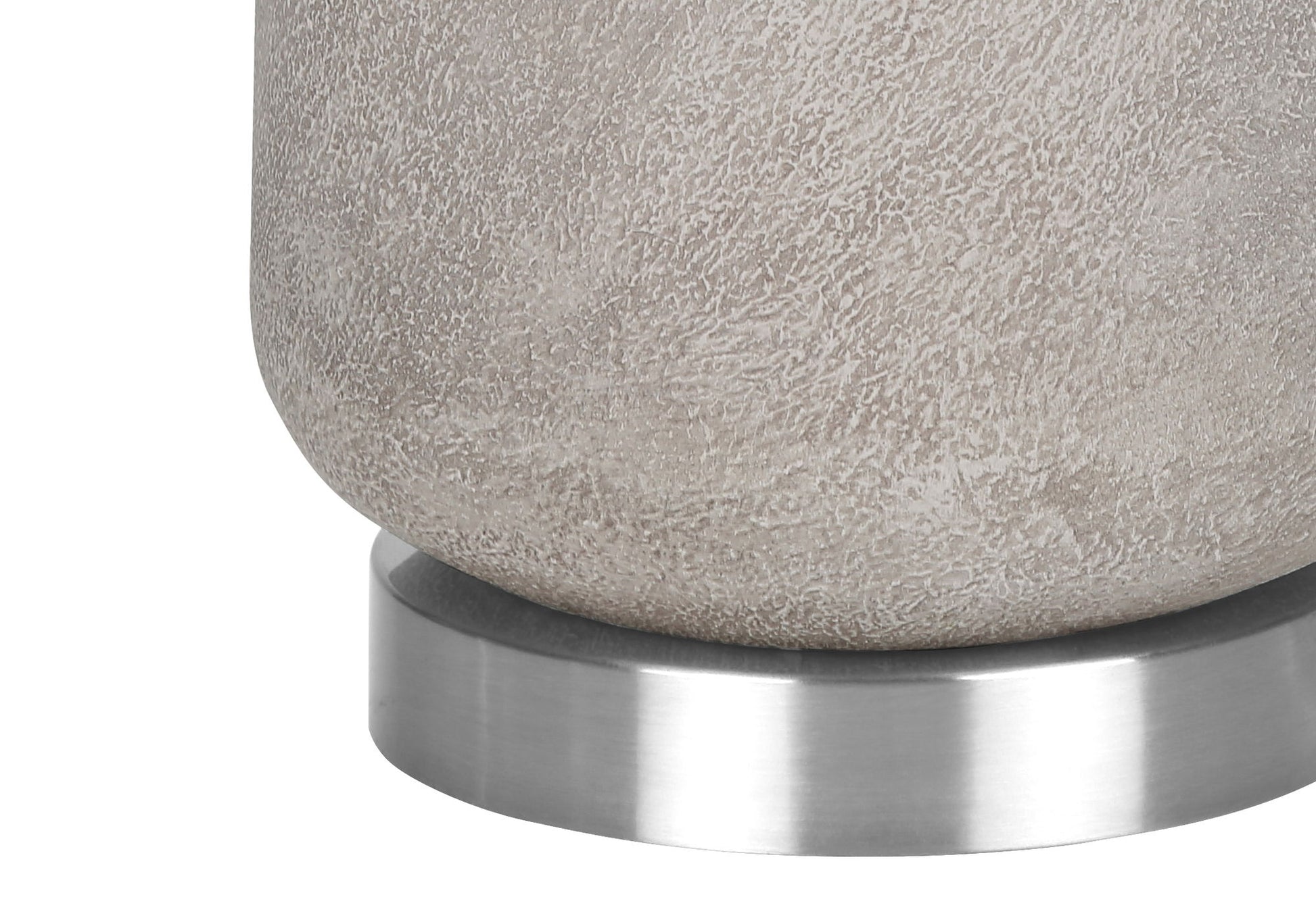 A close-up of the base of the Lighting Table Lamp in modern gray resin, featuring a textured cylindrical design and resting on a smooth, round metallic platform.