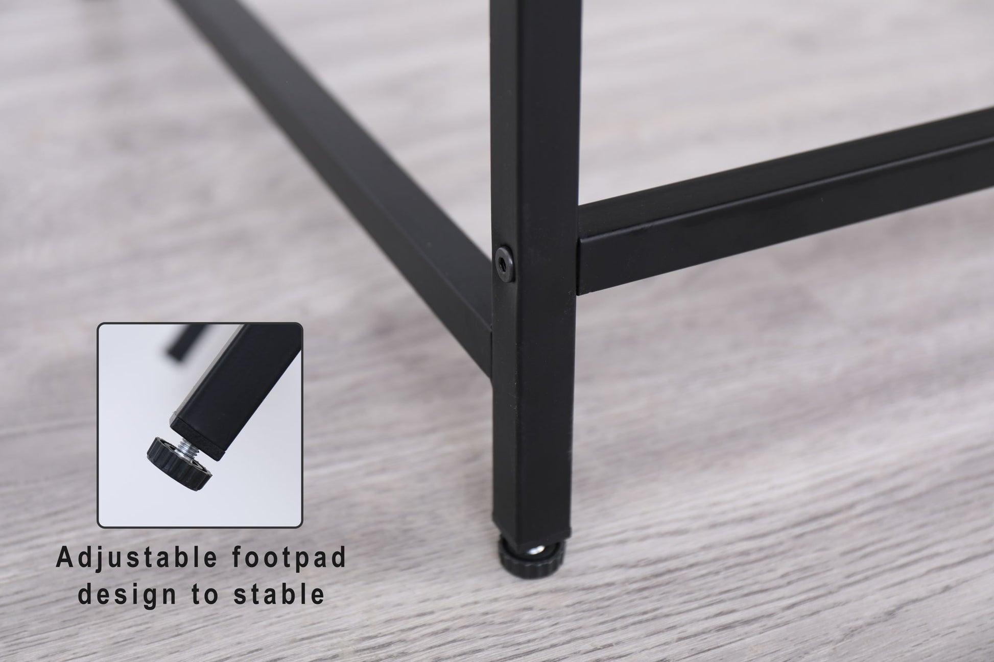 Close-up of the black Console Table's metal leg with an adjustable footpad on a light wood floor. An inset highlights the footpad with text: "Adjustable footpad design for stability.