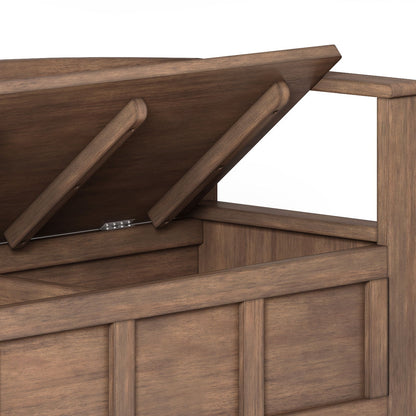The Adams Entryway Storage Bench in Rustic Natural Aged Brown features a paneled design, a lift-up seat with hidden storage, and two support arms to keep the lid open.