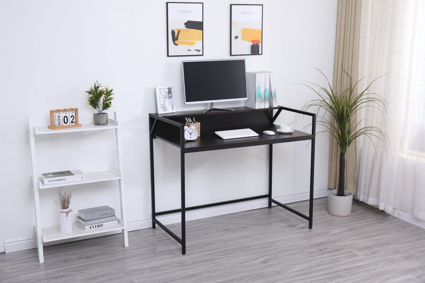 A modern, minimal home office features the Console Table Narrow Modern Entryway Table in black as a sleek desk with a monitor, keyboard, books, potted plants, and decor on a white shelving unit to the side. Sheer curtains let in natural light.
