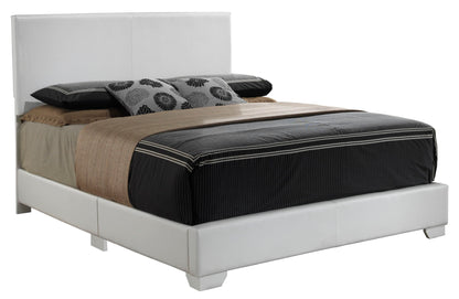 The Elegant Platform Bed For Relaxed Spaces features a white upholstered headboard and frame, dressed in black, brown, and beige bedding with three decorative pillows that have black floral patterns.