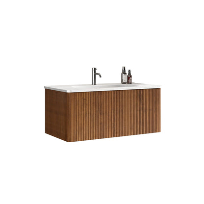 The Etna Striped Bathroom Vanity features a wall-mounted floating design with vertical grooves, a ceramic sink, a modern silver faucet, and two bottles on the right side of the countertop.