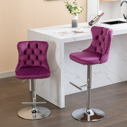Two Swivel Velvet Barstools with tufted purple upholstery, chrome bases, adjustable heights (25-33"), and backs are placed by a white marble kitchen island. A floral vase and wine holder decorate the counter in the background.