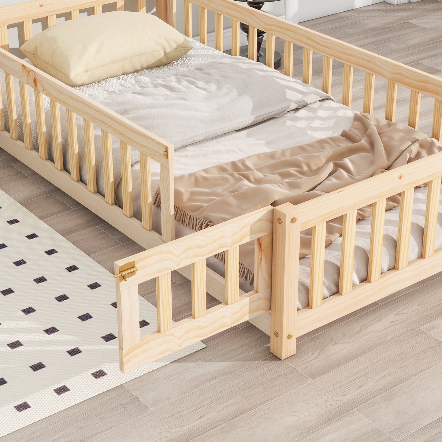 The House-Shaped Headboard Floor Bed With Fence features light wood, railings, a small gate (shown open), a beige blanket, and a cream pillow. It's placed on a light wood floor beside a white rug with black squares.