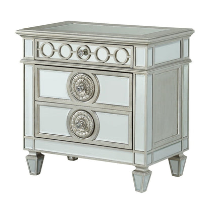 The Varian Mirrored Nightstand in Silver features two drawers, elegant circular accents, silver trim, and tapered legs for a glamorous look.
